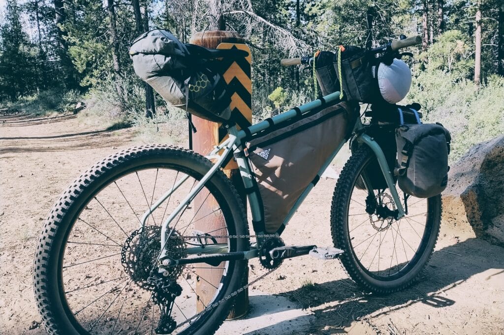 Surly grappler loaded up with bikepacking gear in the middle of a forest road.