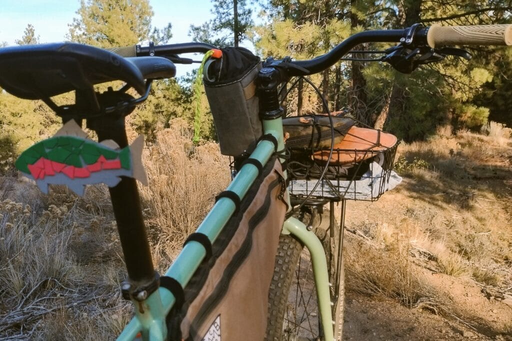 Tight handlebar view of a Surly Grappler with a fish charm hanging under the saddle.