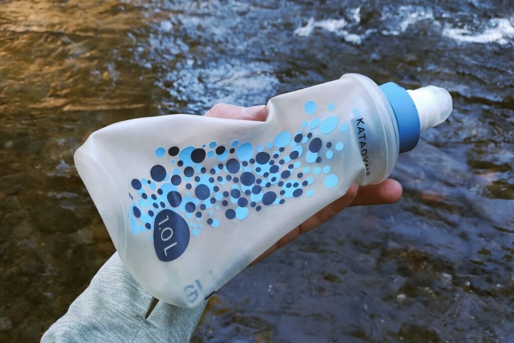 Katadyn BeFree Water Filtration System 1.0L held in front of a creek.