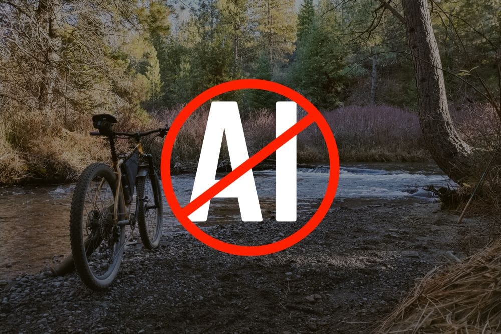 An anti-artificial intelligence image in front of a photo of a bike near a creek.
