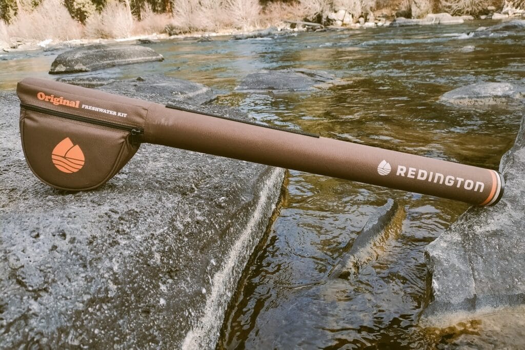 Redington Original Freshwater Kit rod case on rocks in a river.