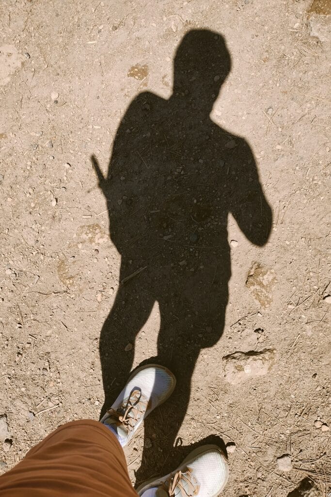 Shadow of a man with his shoes visible in the bottom of the photo.