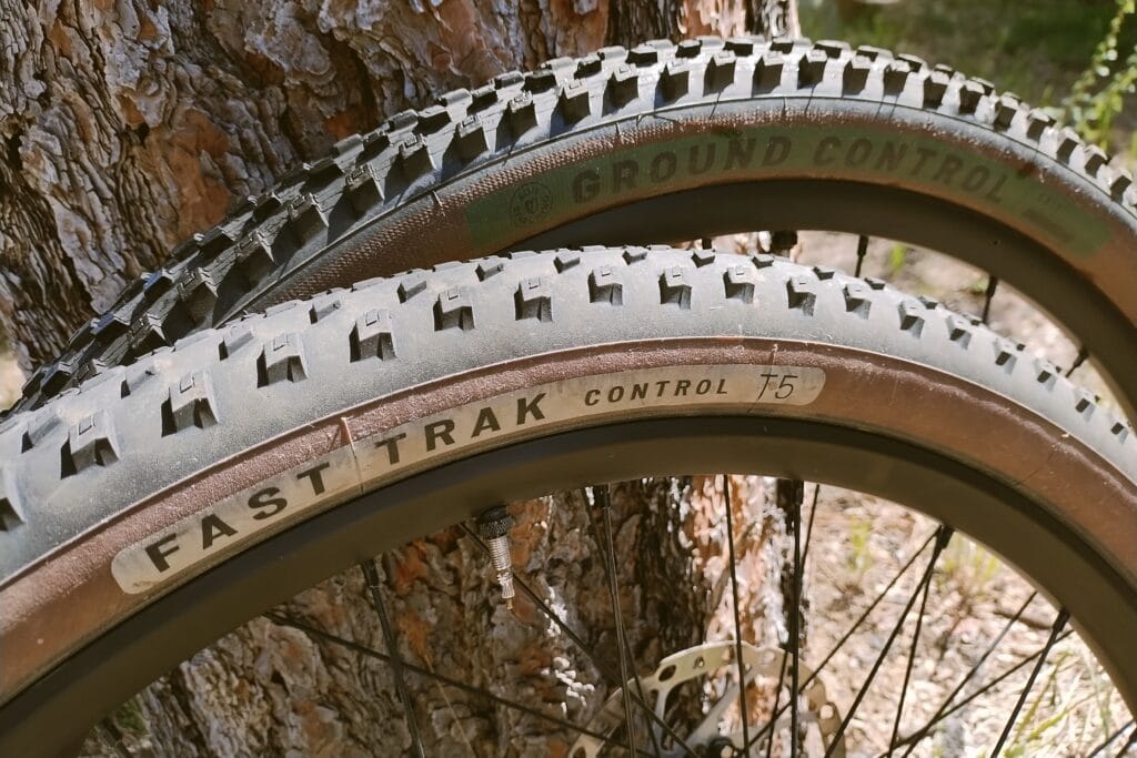 Specialized Fast Trak and Ground Control tires leaned against a pine tree.