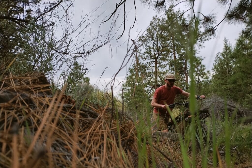 A man pushing his fully loaded bike out of a canyon.